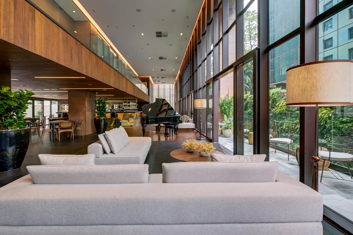 Lobby do Qoya São Paulo com piano e janelões